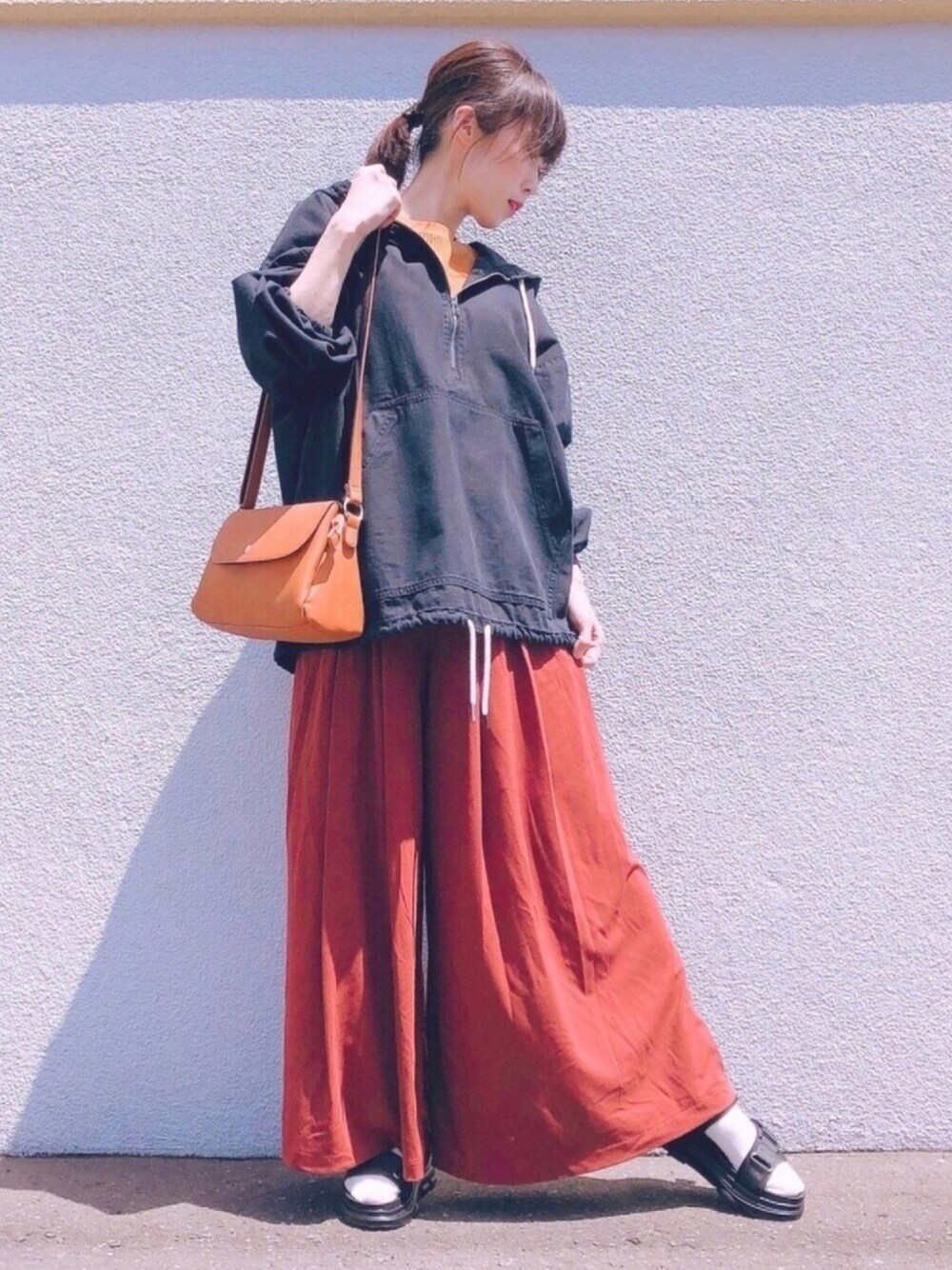 ブラウン系のその他パンツ、イエロー系のショルダーバッグ、ブラック系のサンダルを着用したレディースの春コーディネートの1枚目の写真