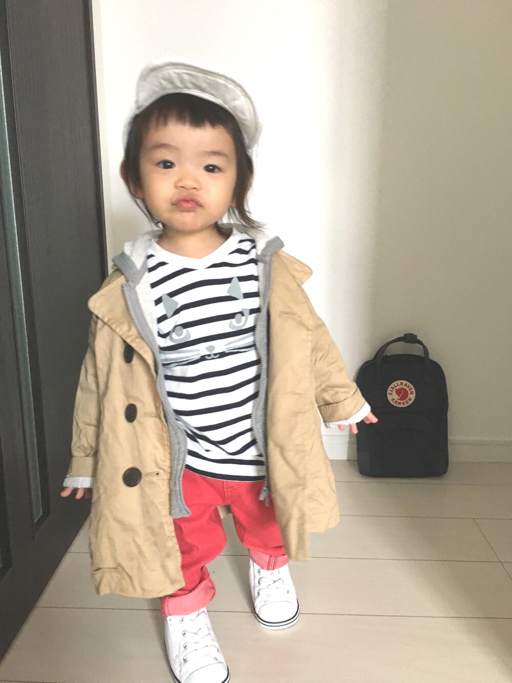 「女の子、1歳9ヶ月、カジュアルコーデ、トレンチコート、キャップ、パーカー、ボーダー、赤パンツ、コンバース、カンケン」｜「BRANSHESのトレンチコート（トレンチコート、ベージュ系）」を使った、Suikaaさん（キッズ・80cm）の冬コーディネートの1枚目の写真