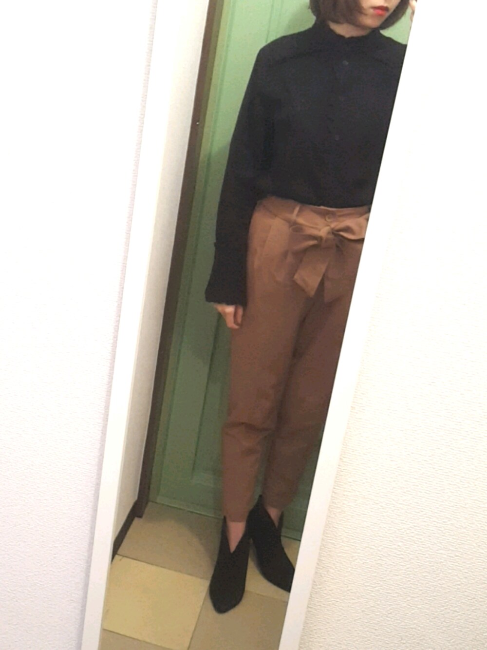 ブラック系のシャツ/ブラウス、ベージュ系のパンツを着用したレディースの秋コーディネートの1枚目の写真