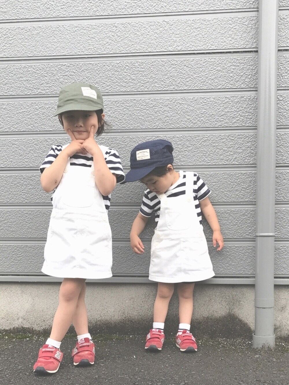 レッド系のスニーカー、ホワイト系のサロペット/オーバーオール、ホワイト系のTシャツ/カットソーを着用したキッズの春コーディネートの1枚目の写真