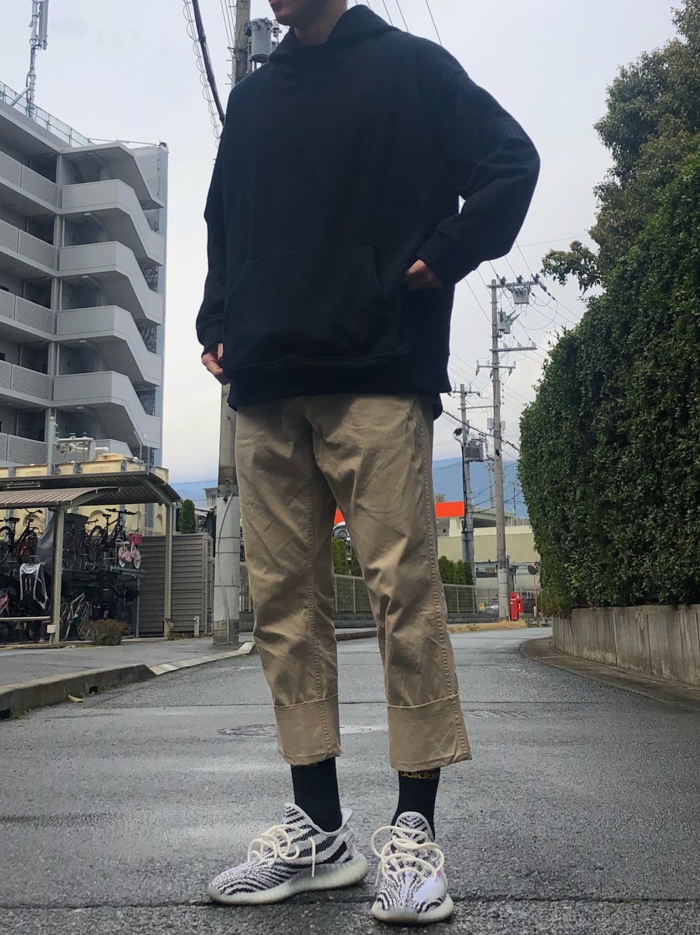 「シンプルコーデ、ゆるコーデ、ロールアップ、kithnyc、gosharubchinskiy、YeezyBoost350、チノパン、黒パーカー、ベージュ×ブラック、kith」｜「Yeezyのアイテム（スニーカー、ホワイト系）」を使った、natsukiさん（メンズ・187cm）の春コーディネートの1枚目の写真
