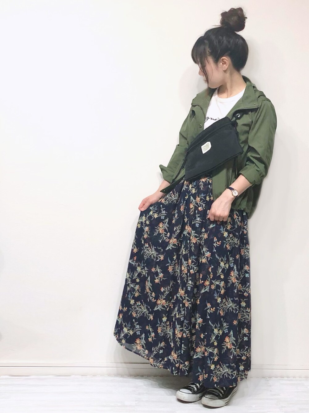 グリーン系のマウンテンパーカー、ホワイト系のTシャツ/カットソー、ブラック系のショルダーバッグを着用したレディースの春コーディネートの1枚目の写真