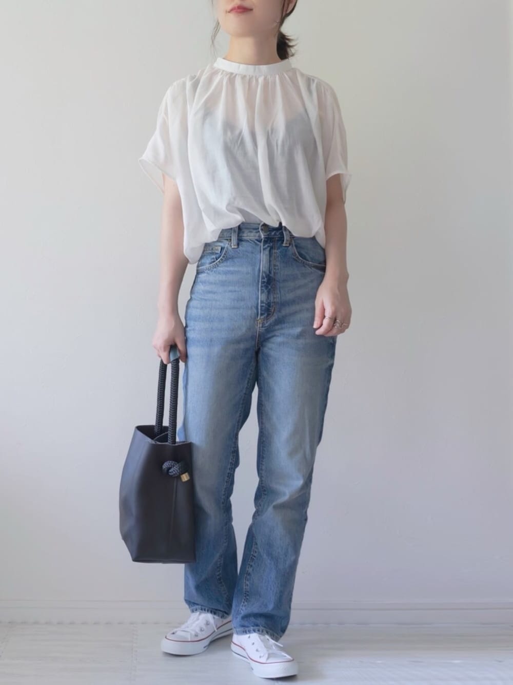 ホワイト系のシャツ/ブラウス、ブルー系のデニムパンツ、ブラック系のハンドバッグを着用したレディースの夏コーディネートの1枚目の写真