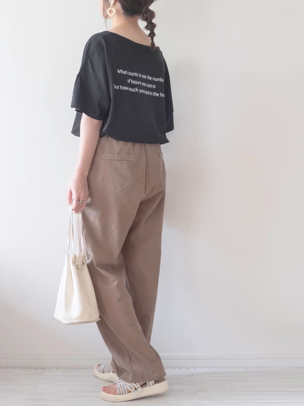 ブラック系のTシャツ/カットソー、ベージュ系のショルダーバッグ、ブラウン系のスラックスを着用したレディースの夏コーディネートの1枚目の写真