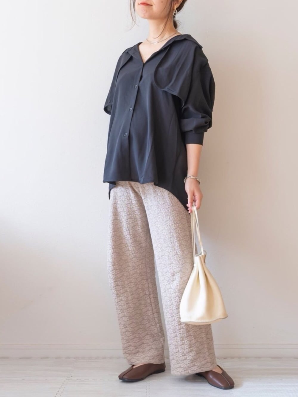 ベージュ系のその他パンツ、ブラウン系のパンプス、ベージュ系のショルダーバッグを着用したレディースの春コーディネートの1枚目の写真