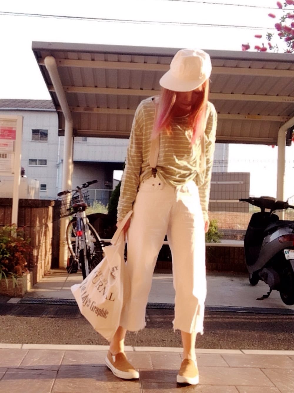 グレー系のTシャツ/カットソー、ブルー系のデニムパンツ、ホワイト系のトートバッグを着用したレディースの春コーディネートの1枚目の写真