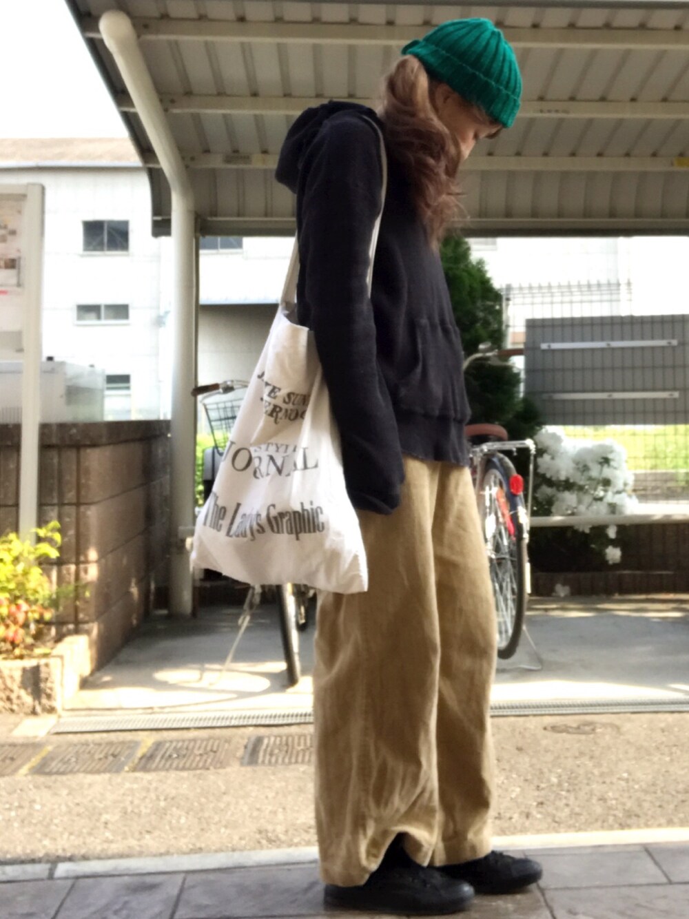 ホワイト系のトートバッグ、ブラック系のパーカー、イエロー系のその他パンツを着用したレディースの春コーディネートの1枚目の写真