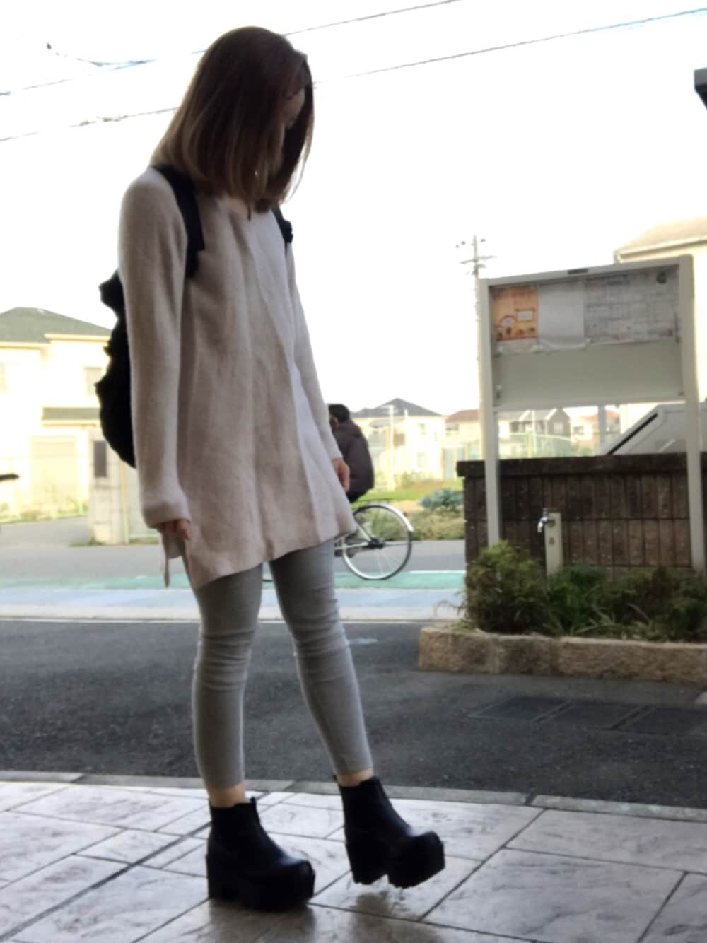 ベージュ系のワンピース、ブラック系のバックパック/リュック、ブラック系のブーツを着用したレディースの秋コーディネートの1枚目の写真
