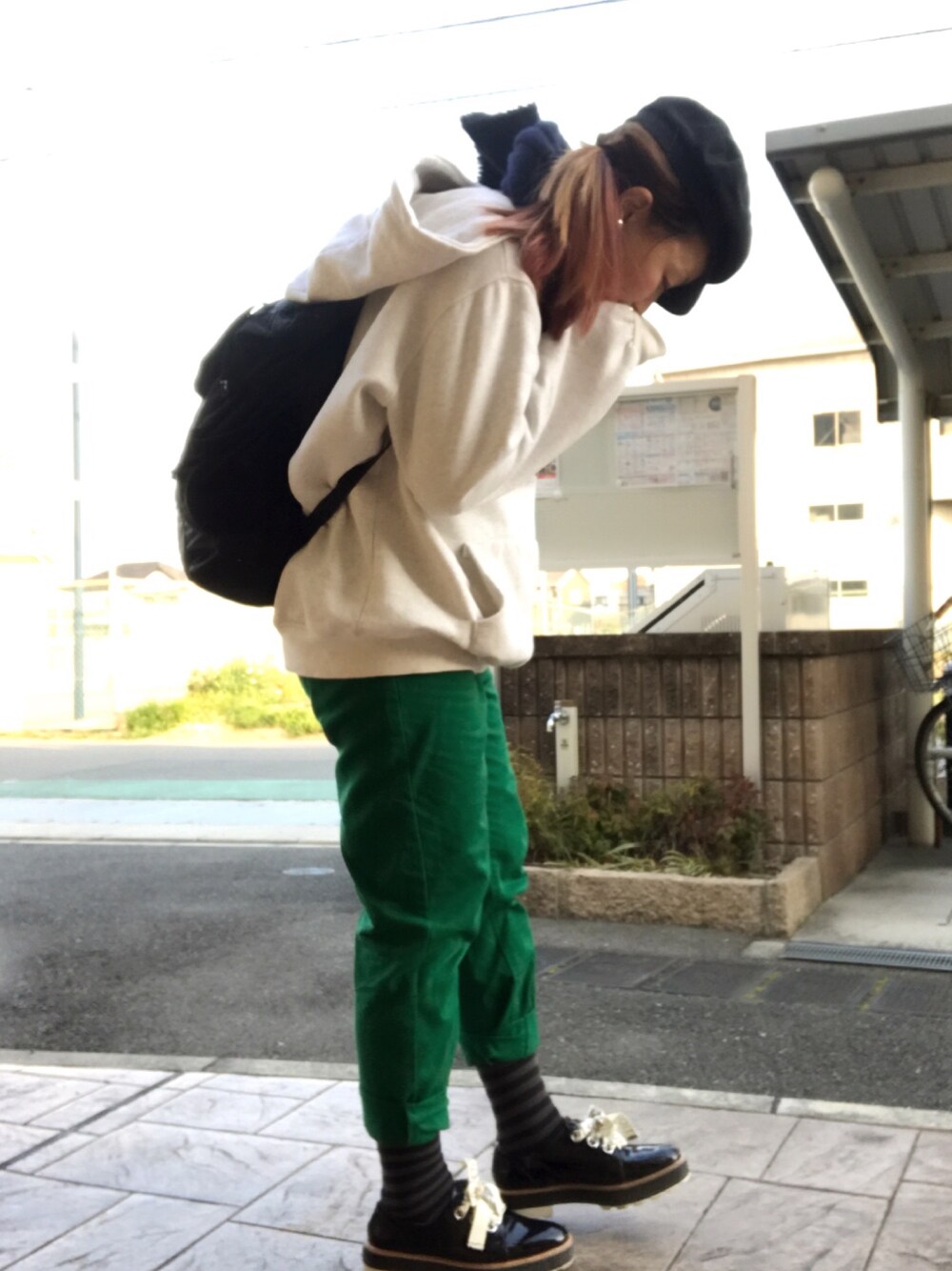 ブラック系のバックパック/リュック、ベージュ系のパーカー、グリーン系のチノパンツを着用したレディースの冬コーディネートの1枚目の写真