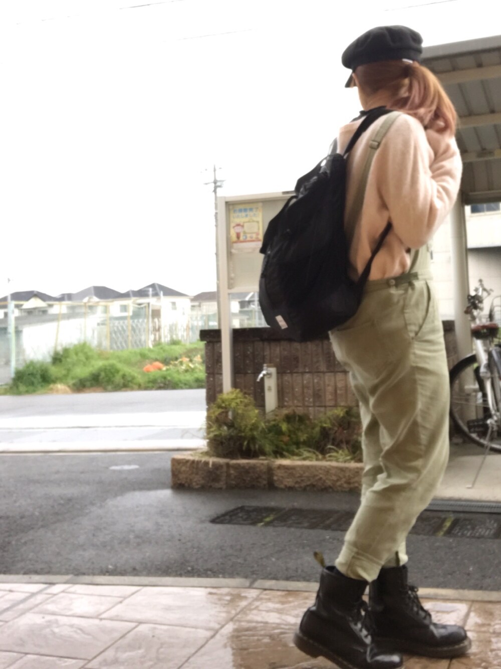 ピンク系のニット/セーター、ブラック系のバックパック/リュック、グリーン系のサロペット/オーバーオールを着用したレディースの春コーディネートの1枚目の写真