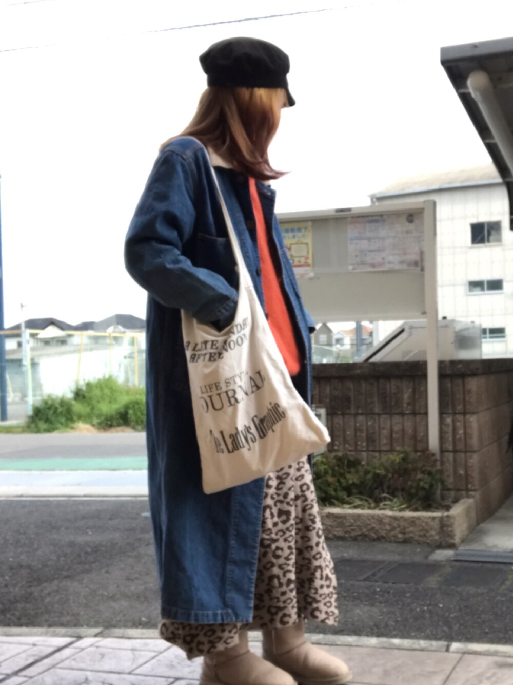 オレンジ系のニット/セーター、ホワイト系のトートバッグ、ブルー系のチェスターコートを着用したレディースの春コーディネートの1枚目の写真