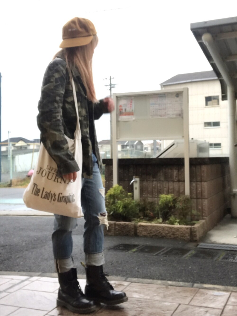 ブルー系のニット/セーター、グリーン系のミリタリージャケット、ホワイト系のトートバッグを着用したレディースの冬コーディネートの1枚目の写真