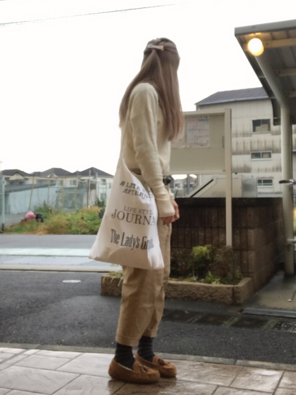 ホワイト系のニット/セーター、ホワイト系のトートバッグ、ベージュ系のチノパンツを着用したレディースの冬コーディネートの1枚目の写真