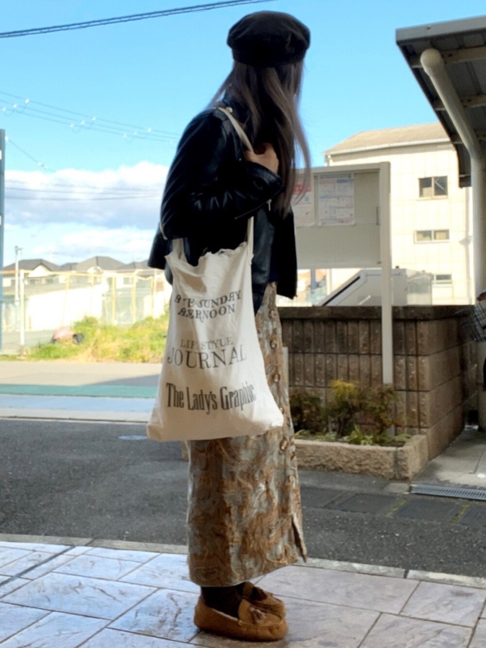 ブルー系のニット/セーター、ホワイト系のトートバッグ、ブルー系のスカートを着用したレディースの冬コーディネートの1枚目の写真