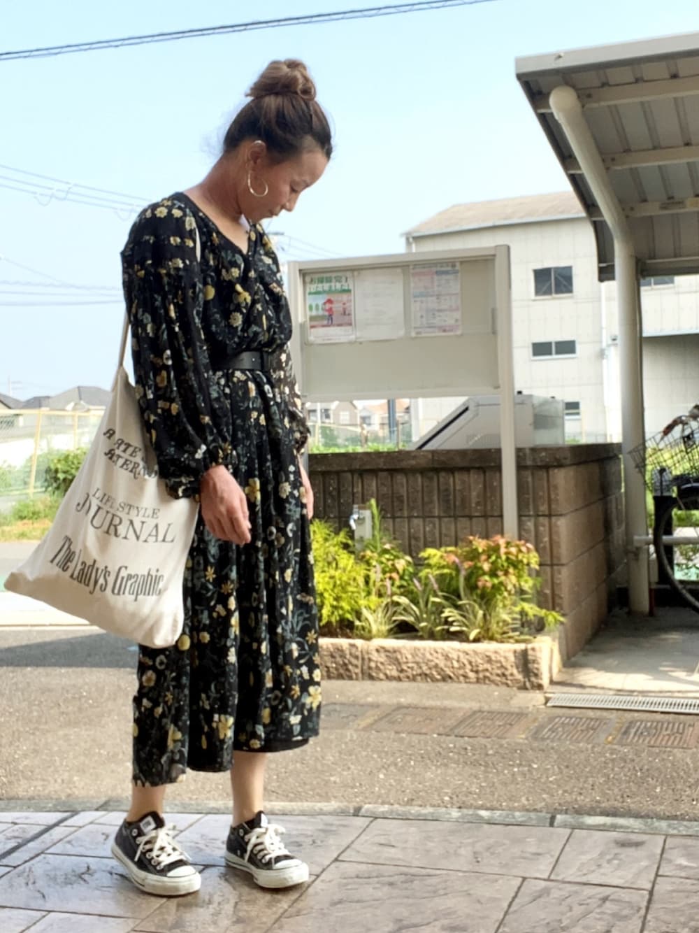 ブラック系のワンピース、ホワイト系のトートバッグ、ブラック系のスニーカーを着用したレディースの夏コーディネートの1枚目の写真