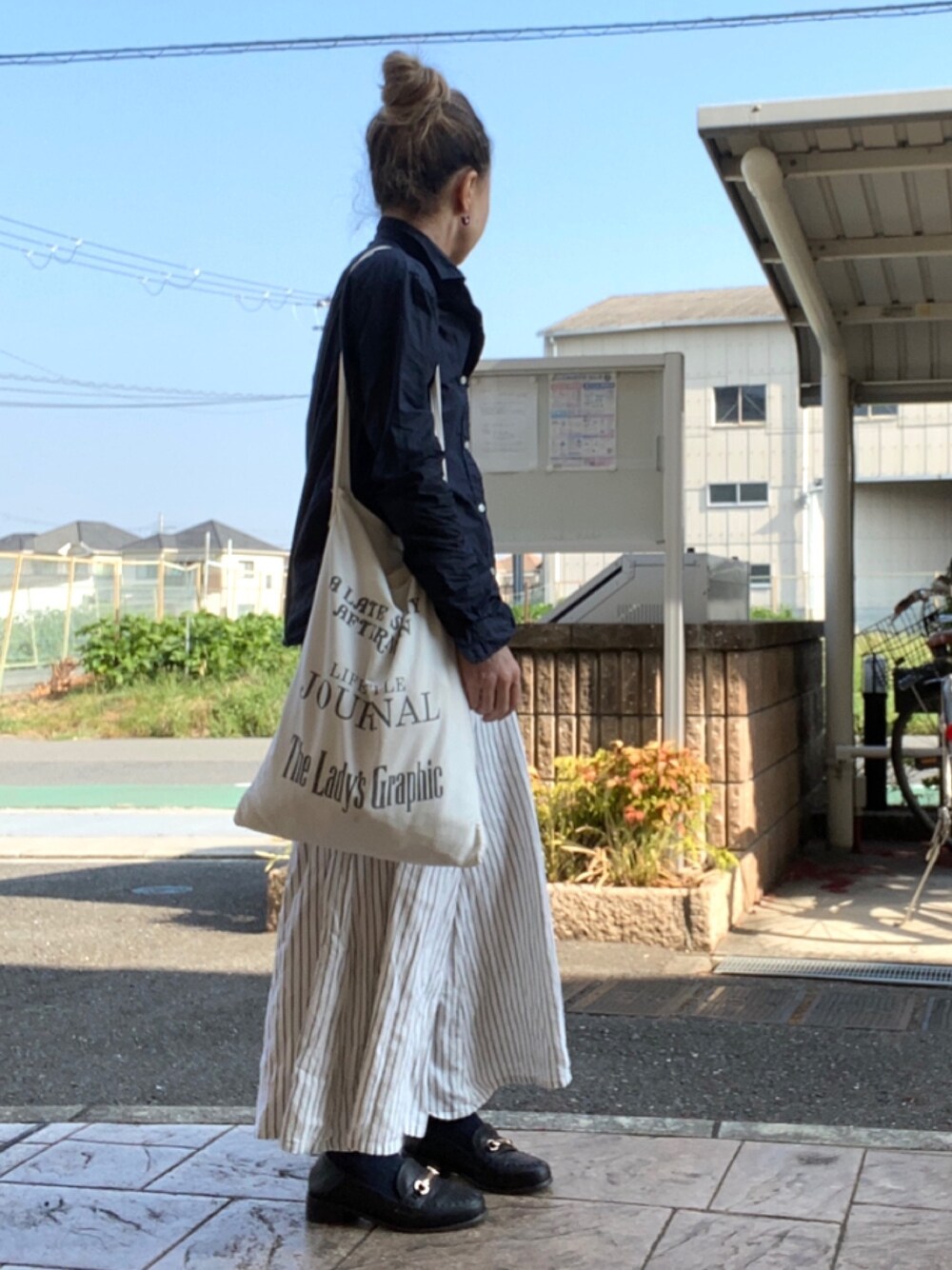 ホワイト系のトートバッグ、ホワイト系のその他パンツ、ブラック系のローファーを着用したレディースの夏コーディネートの1枚目の写真