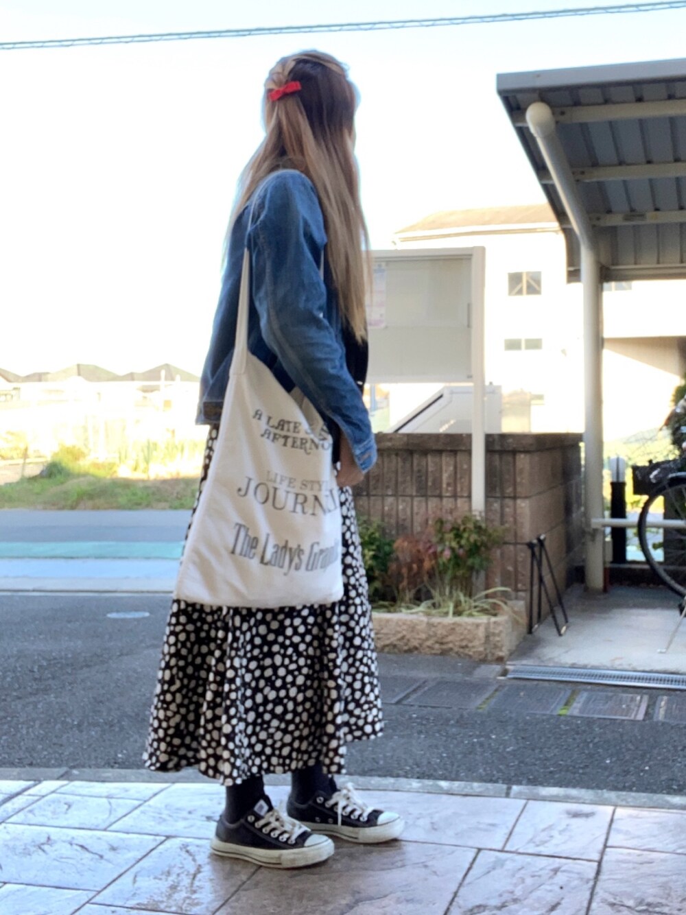 ブラック系のニット/セーター、ホワイト系のトートバッグ、ブラック系のスカートを着用したレディースの冬コーディネートの1枚目の写真