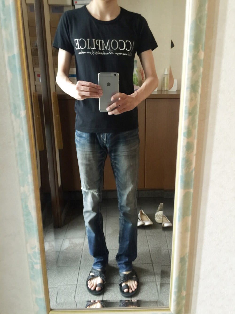 ブラック系のTシャツ/カットソー、ブルー系のデニムパンツ、ブラック系のサンダルを着用したメンズの夏コーディネートの1枚目の写真