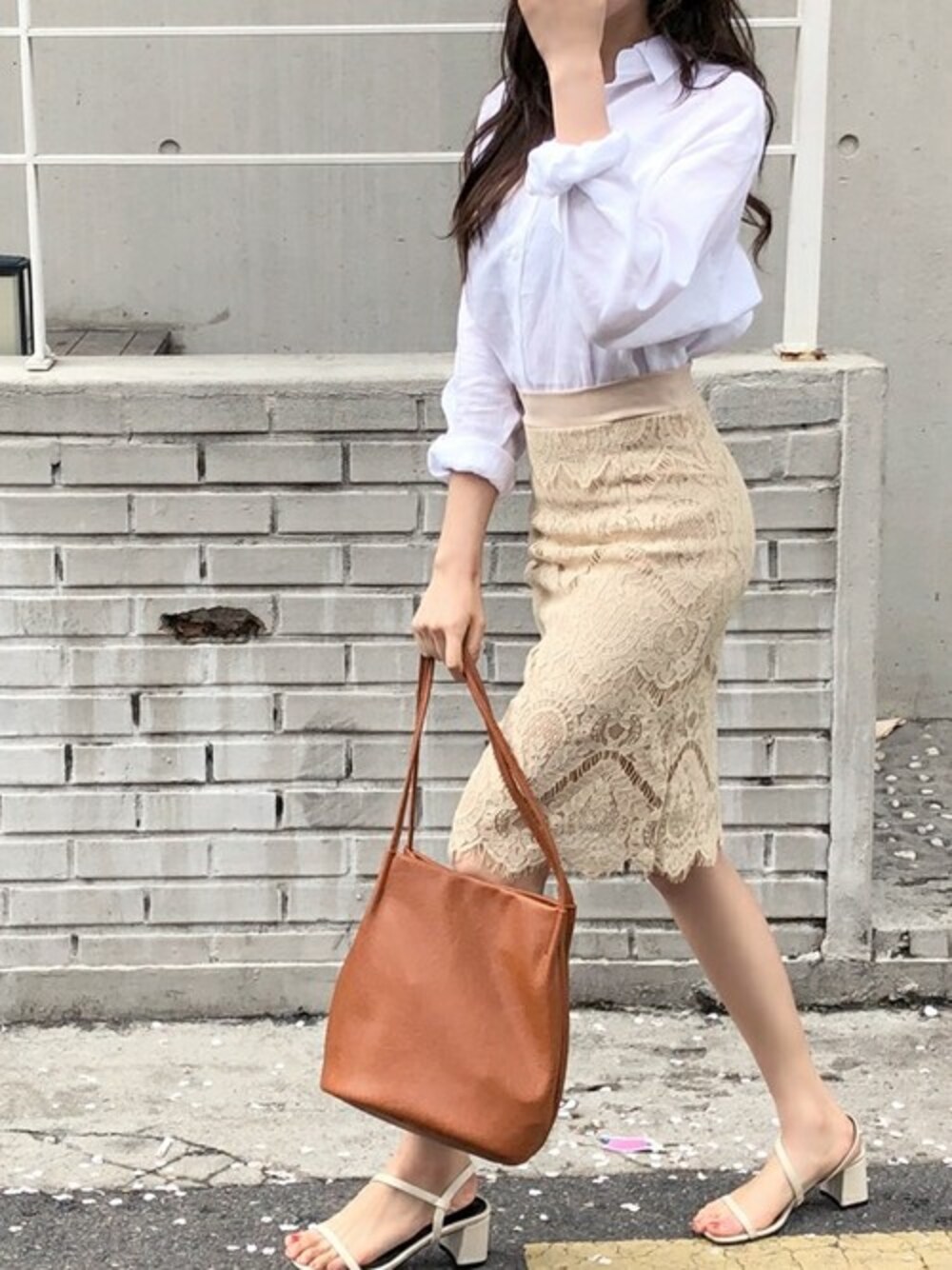 ホワイト系のシャツ/ブラウス、ベージュ系のスカートを着用したレディースの春コーディネートの1枚目の写真