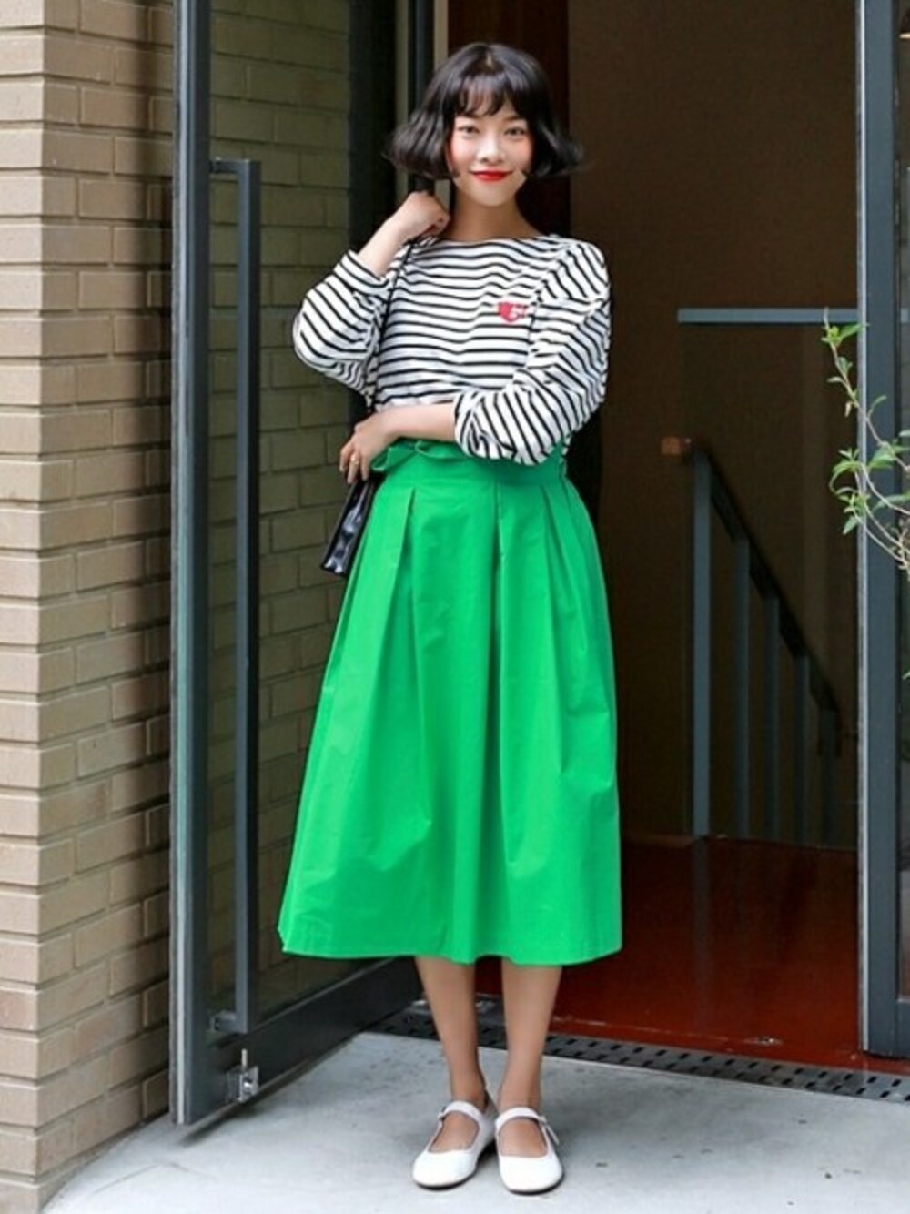 ブラック系のTシャツ/カットソー、グリーン系のスカート、ブラック系のショルダーバッグを着用したレディースの夏コーディネートの1枚目の写真