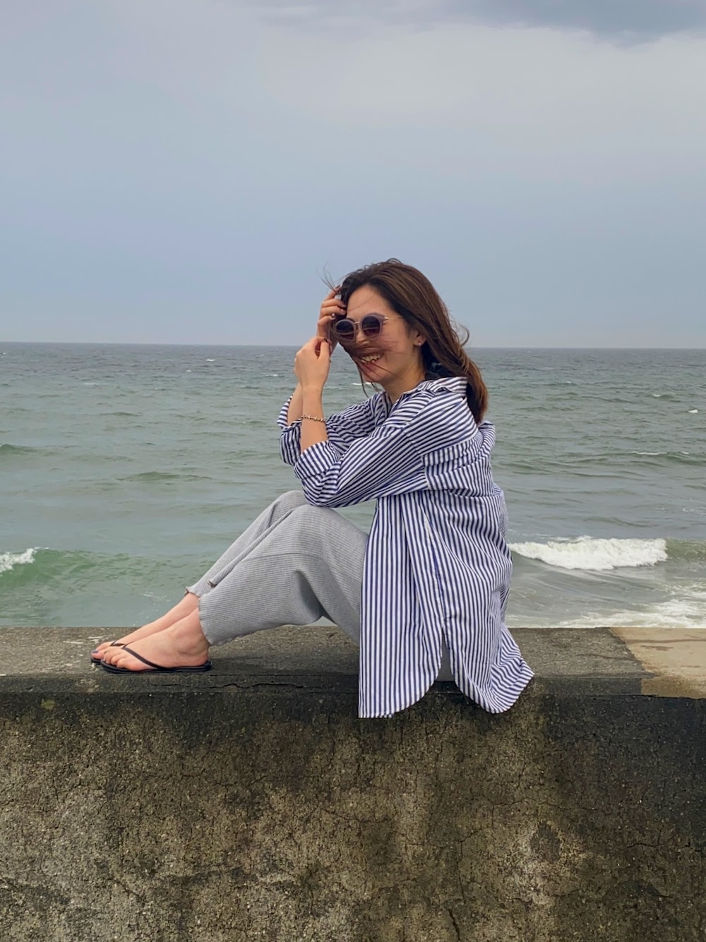 「夏コーデ、カジュアル、パンツスタイル、ゆるコーデ、海、ootd、シャツスタイル、大人カジュアル、ユニクロ、ビーチサンダル」｜「UNIQLOのエクストラファインコットンオーバーサイズロングシャツ（ストライプ・長袖）（シャツ/ブラウス、ブルー系）」を使った、m y u.さん（レディース・158cm）の夏コーディネートの1枚目の写真