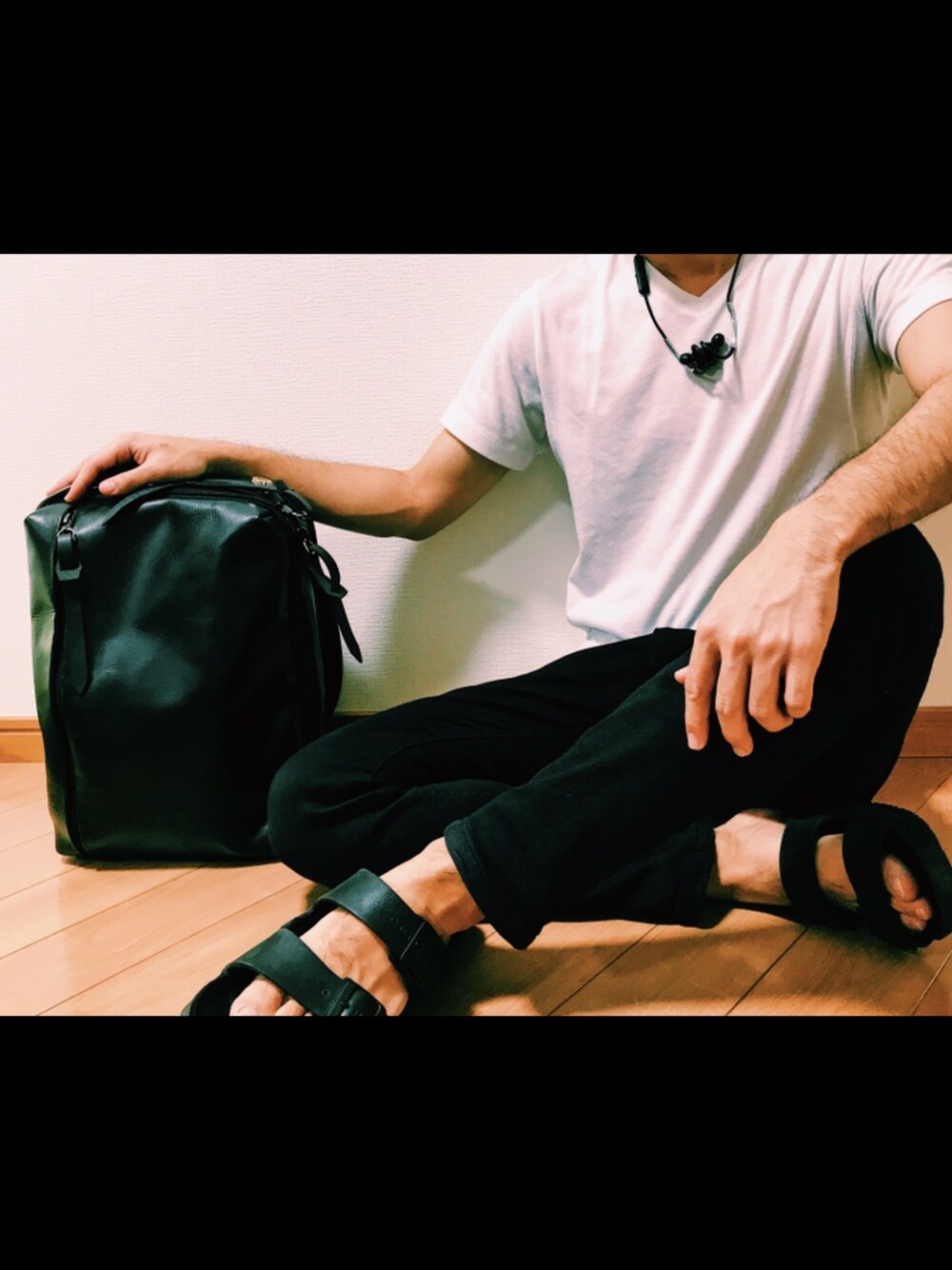 ホワイト系のTシャツ/カットソー、ブラック系のパンツ、ブラック系のサンダルを着用したメンズの春コーディネートの1枚目の写真