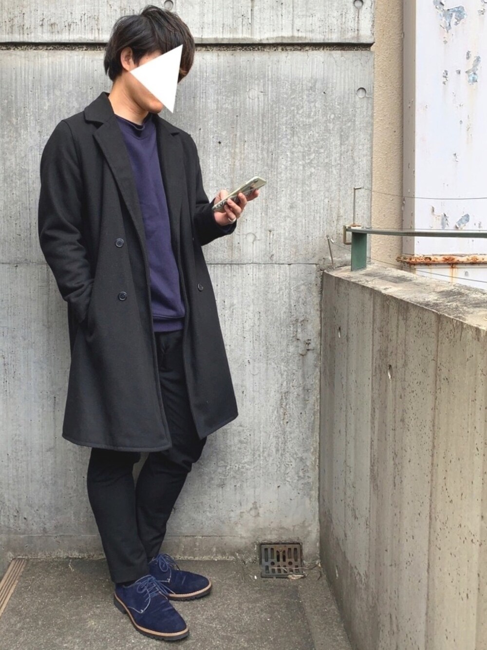 ブラック系のチェスターコート、ブルー系のスウェット、ブルー系のTシャツ/カットソーを着用したメンズの冬コーディネートの1枚目の写真