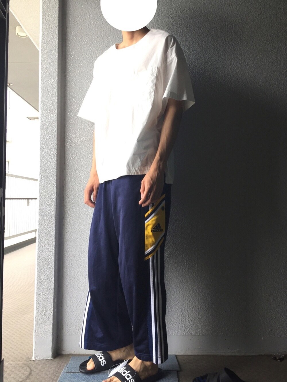 ホワイト系のTシャツ/カットソー、ブルー系のパンツ、ブラック系のサンダルを着用したメンズの夏コーディネートの1枚目の写真