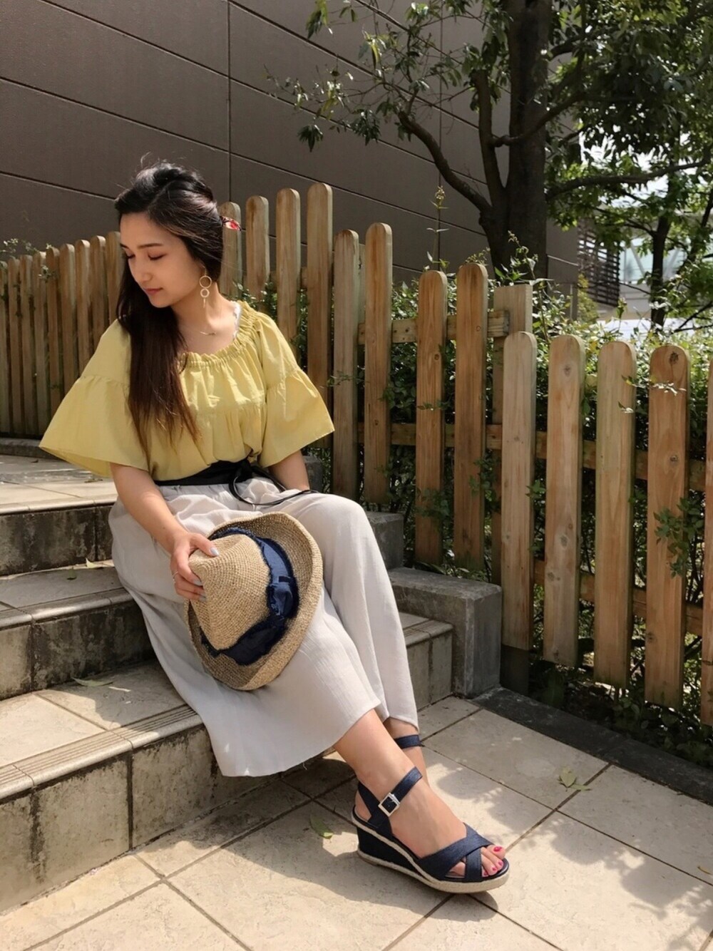 イエロー系のシャツ/ブラウス、ブルー系のサンダル、ベージュ系のその他パンツを着用したレディースの春コーディネートの1枚目の写真