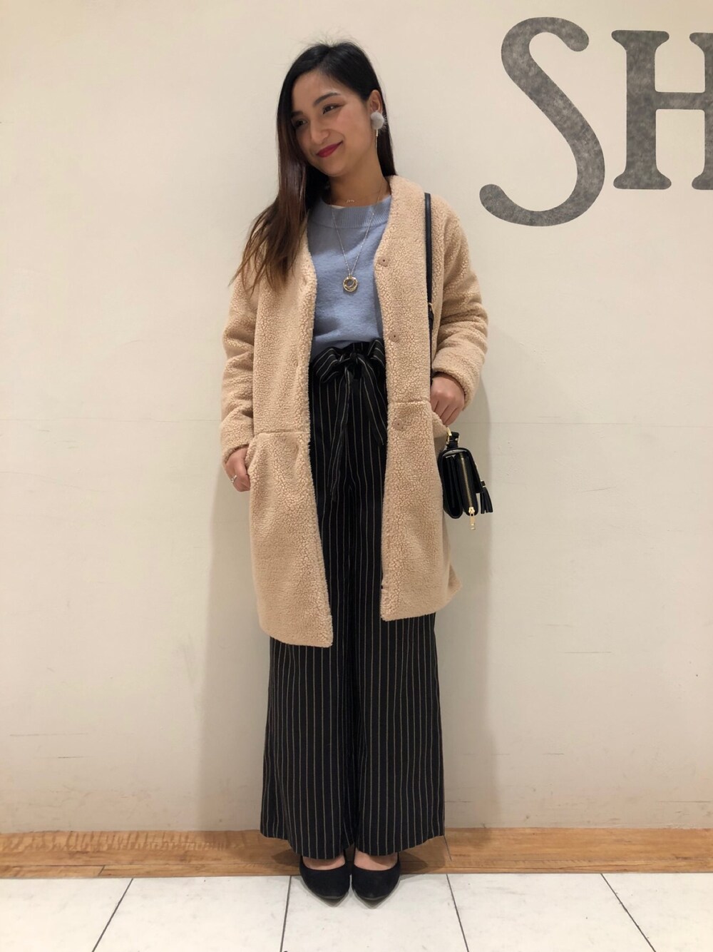 ベージュ系のその他アウター、ブルー系のニット/セーター、ブラック系のその他パンツを着用したレディースの冬コーディネートの1枚目の写真