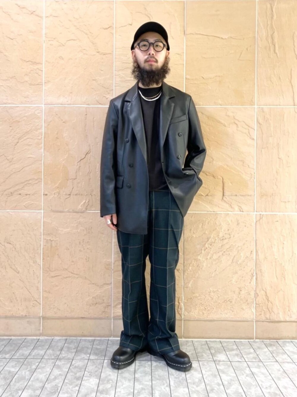 ブラック系のブーツ、ブラック系のTシャツ/カットソー、グリーン系のスラックスを着用したメンズの秋コーディネートの1枚目の写真