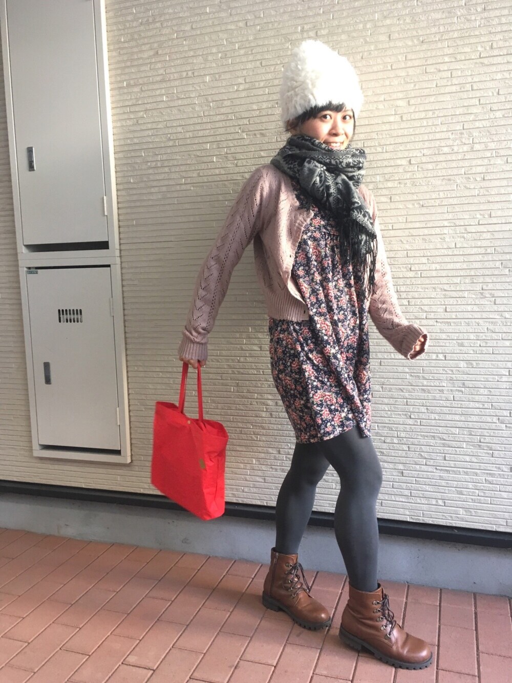 ブルー系のワンピース、ピンク系のカーディガン/ボレロ、ブラウン系のブーツを着用したレディースの冬コーディネートの1枚目の写真