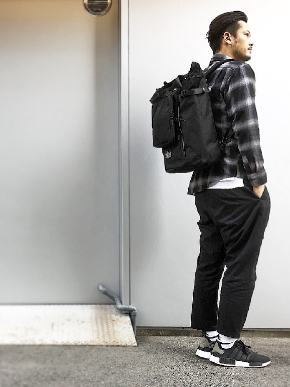 ブラック系のバックパック/リュック、ブラック系のスニーカー、ブラック系のその他パンツを着用したメンズの春コーディネートの1枚目の写真