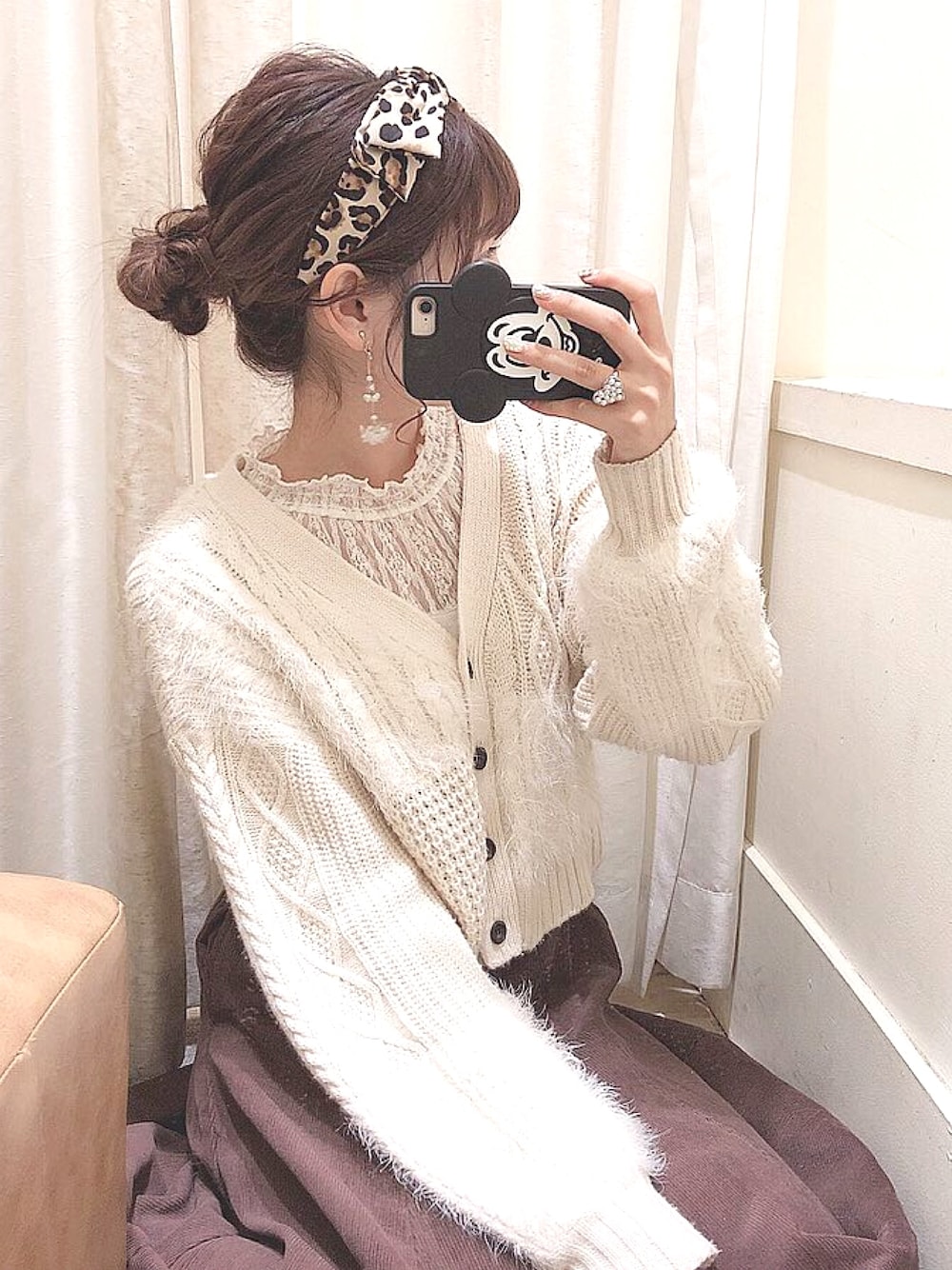 ホワイト系のカーディガン/ボレロ、ブラウン系のスカート、ベージュ系のカチューシャを着用したレディースの春コーディネートの1枚目の写真