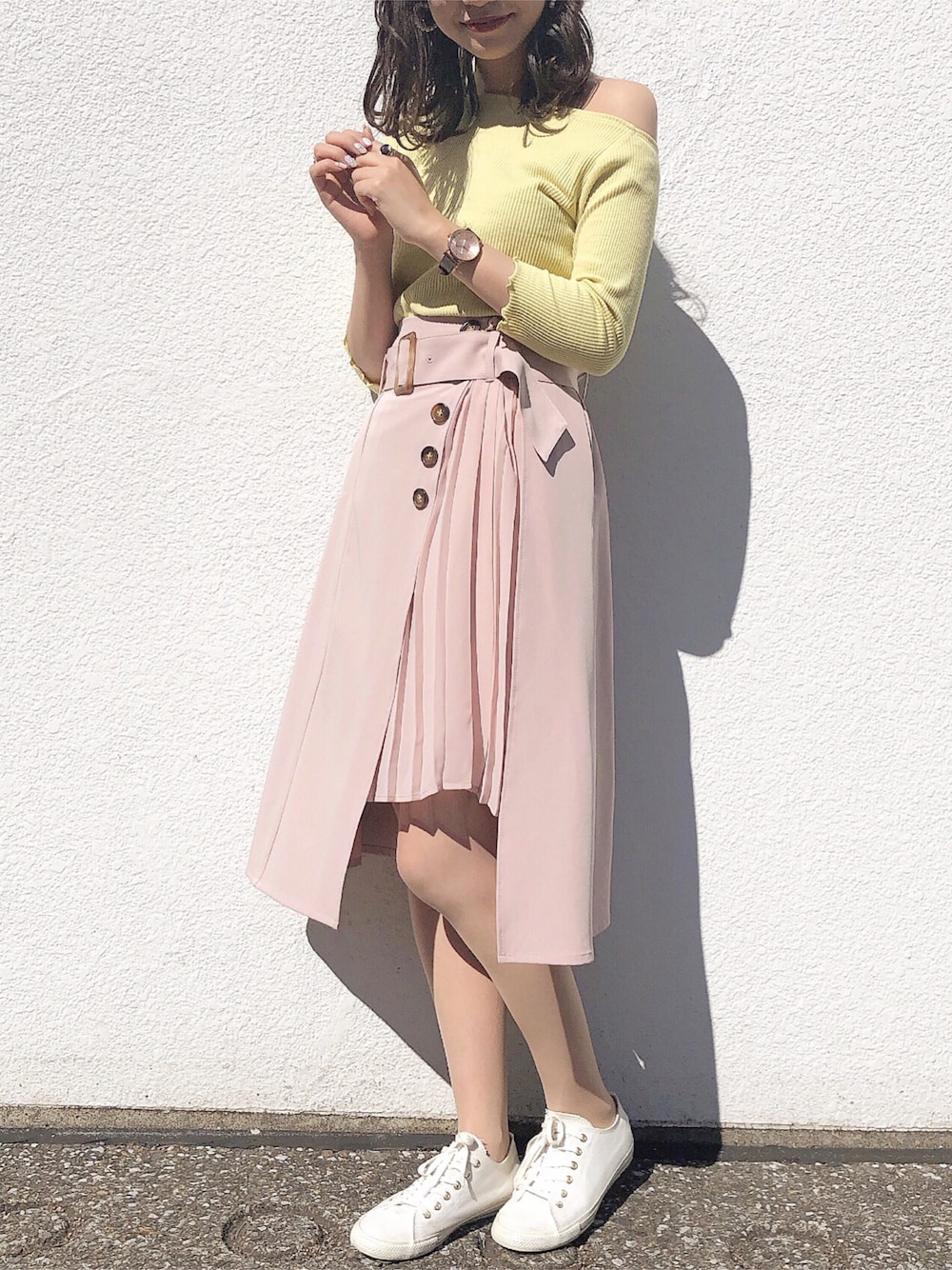 イエロー系のTシャツ/カットソー、ベージュ系のスカート、ゴールド系のアナログ腕時計を着用したレディースの春コーディネートの1枚目の写真