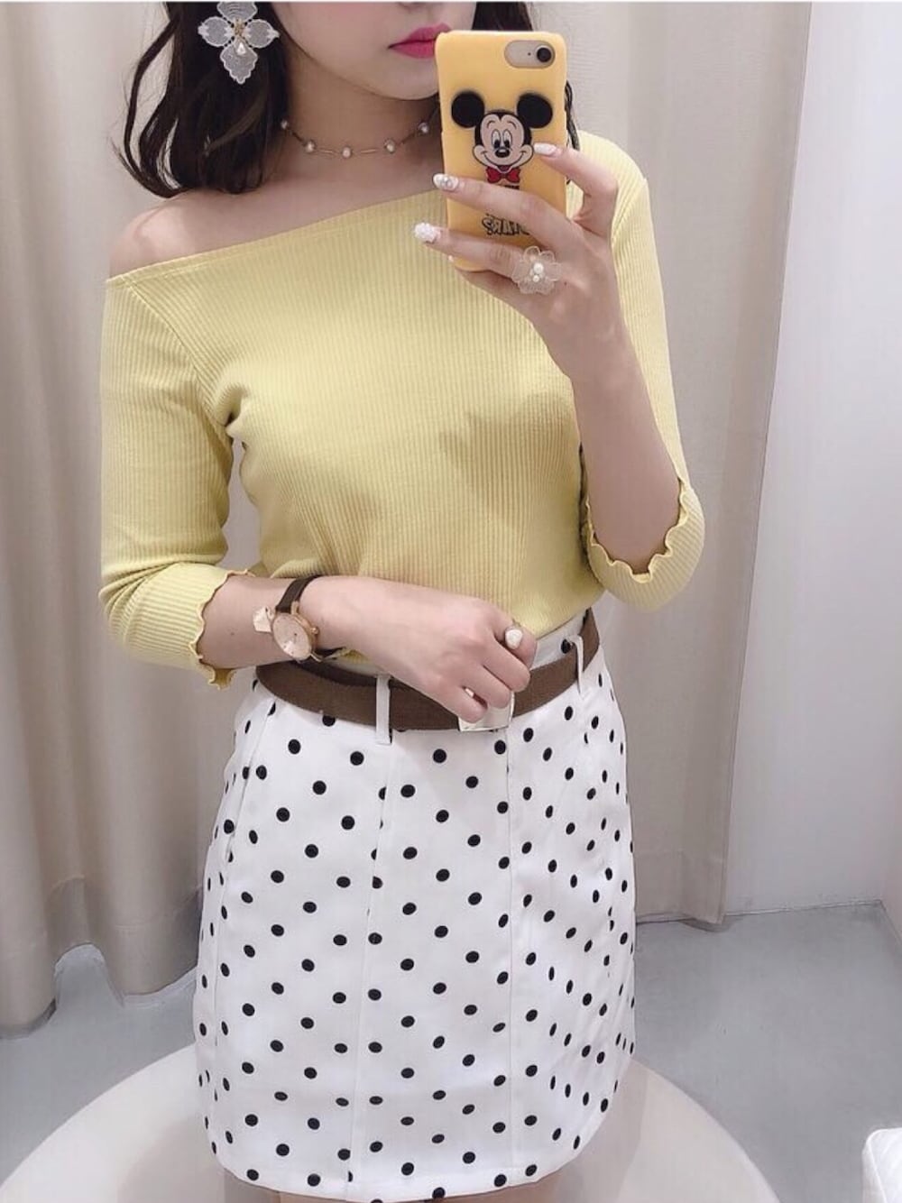 イエロー系のTシャツ/カットソー、ホワイト系のスカート、ゴールド系のアナログ腕時計を着用したレディースの春コーディネートの1枚目の写真