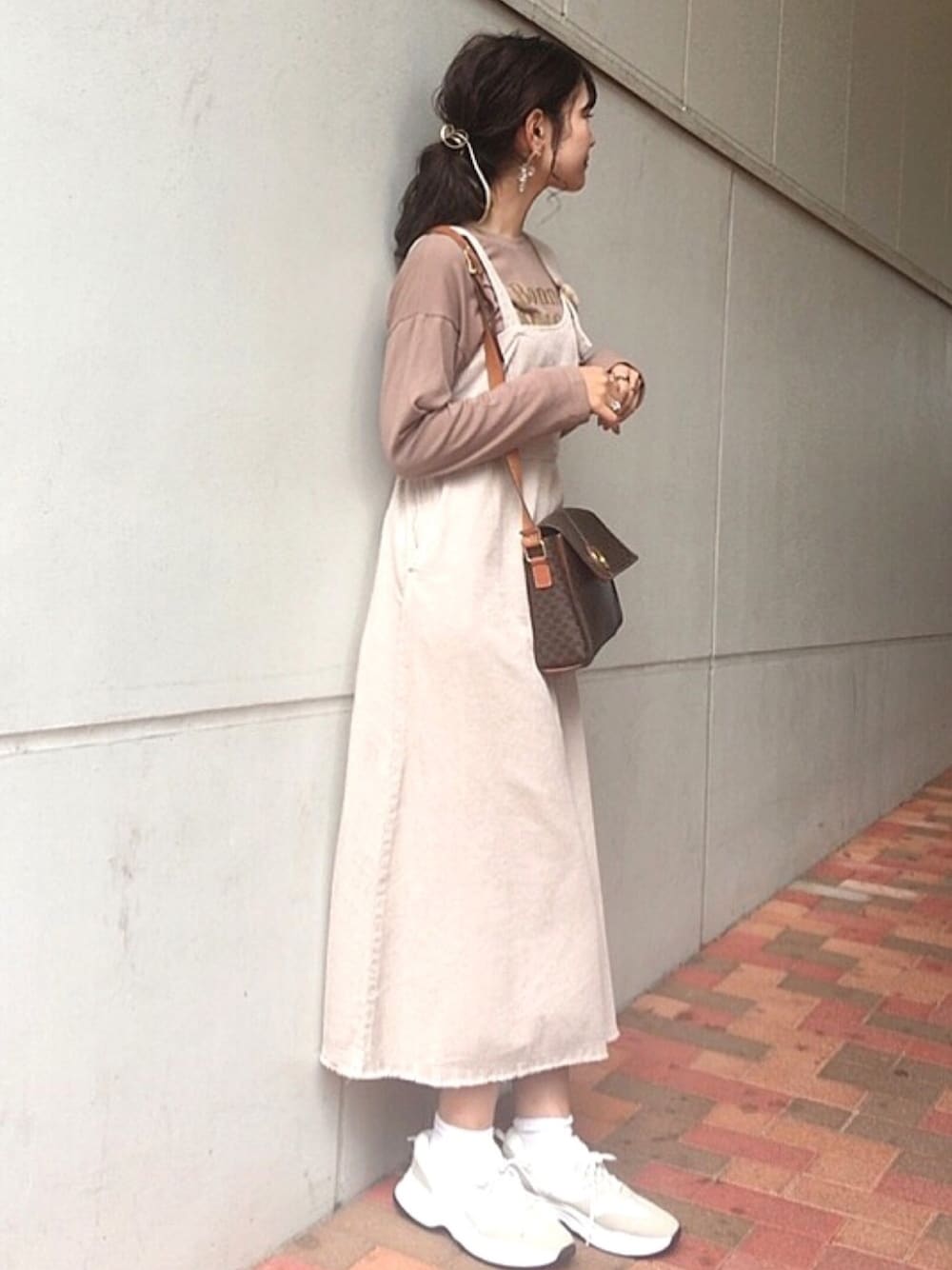 グレー系のジャンパースカートを着用したレディースの秋コーディネートの1枚目の写真