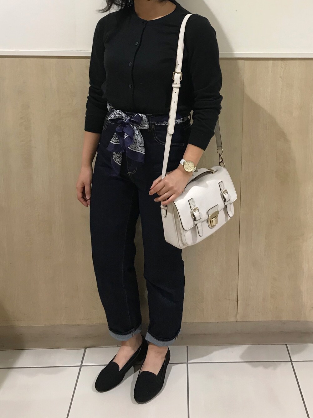ホワイト系のショルダーバッグ、ブラック系のカーディガン/ボレロ、ブラック系のパンプスを着用したレディースの春コーディネートの1枚目の写真