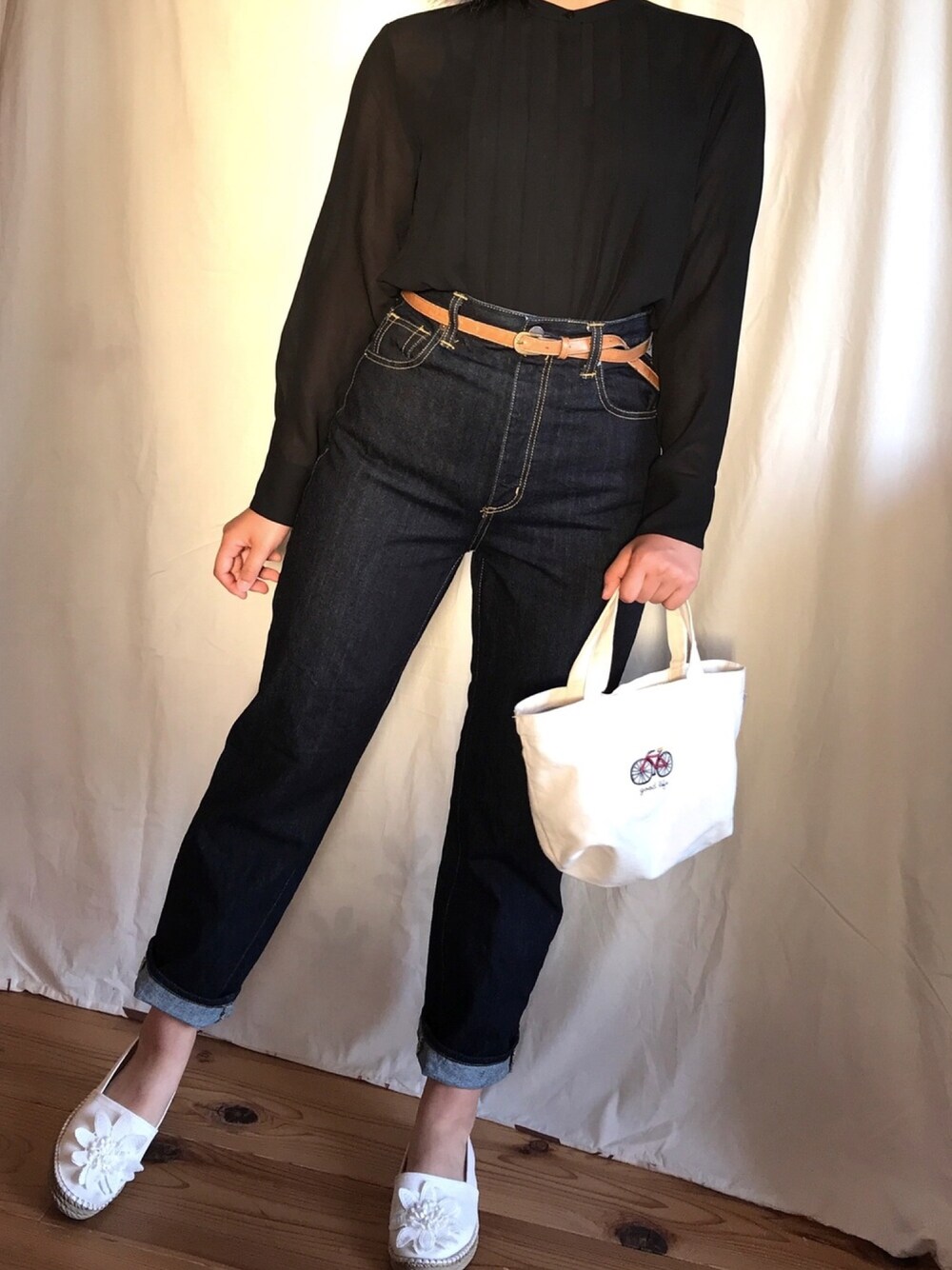 ブルー系のデニムパンツ、ホワイト系のエコバッグ/サブバッグ、ホワイト系のサンダルを着用したレディースの春コーディネートの1枚目の写真