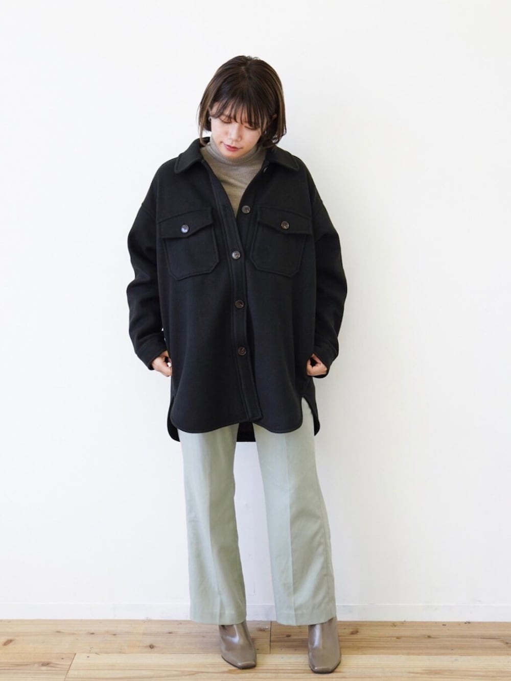 ベージュ系のニット/セーター、ブラック系のカバーオール、グリーン系のその他パンツを着用したレディースの冬コーディネートの1枚目の写真