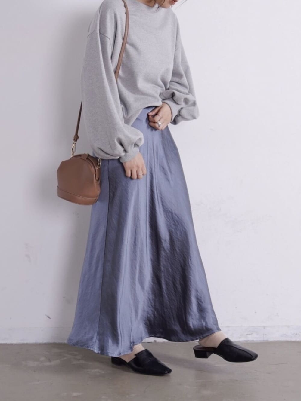 ブルー系のスカート、グレー系のスウェットを着用したレディースの冬コーディネートの1枚目の写真