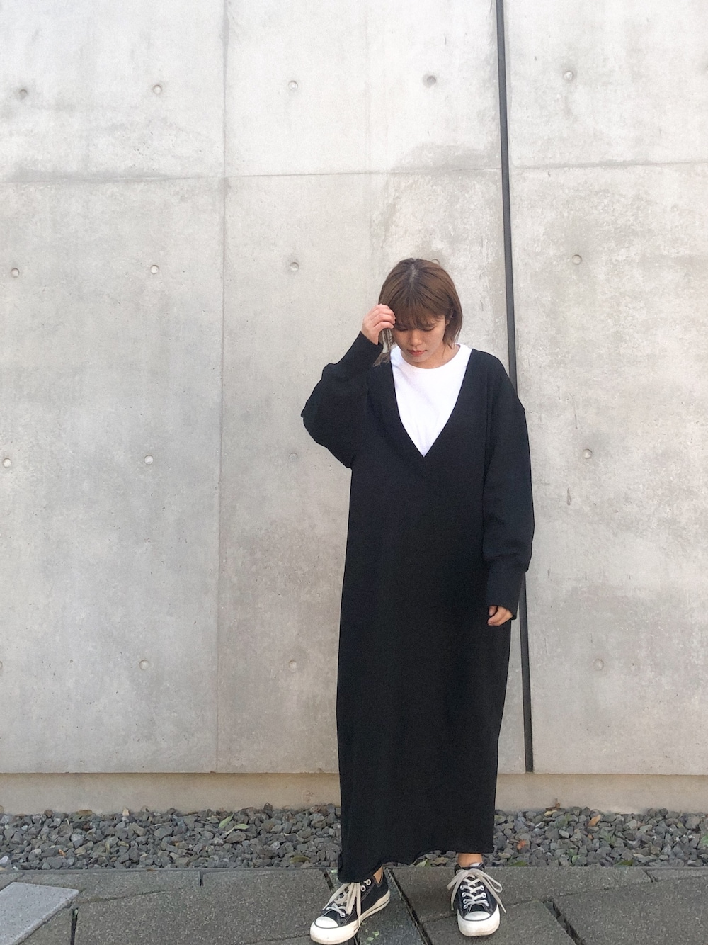 ブラック系のワンピース、ホワイト系のTシャツ/カットソー、ブラック系のスニーカーを着用したレディースの冬コーディネートの1枚目の写真