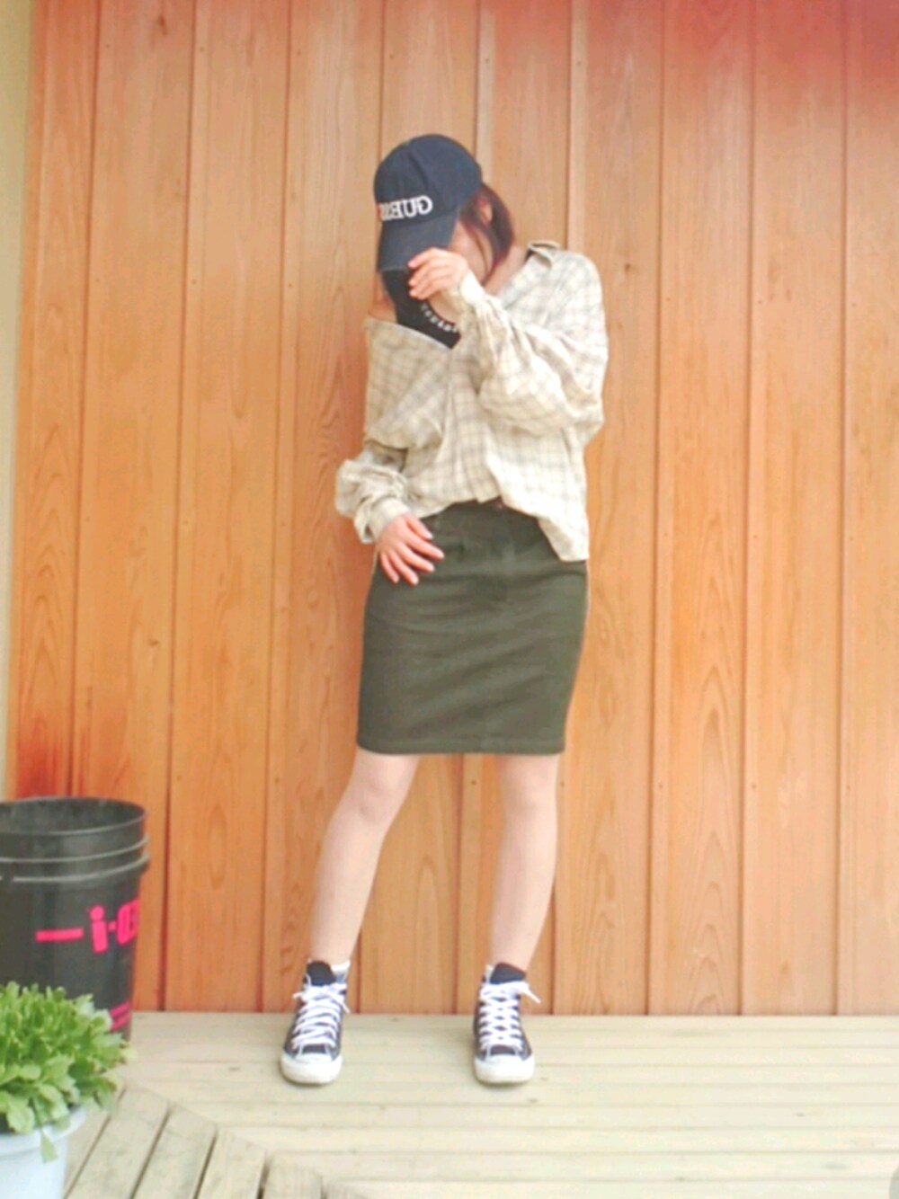 ホワイト系のシャツ/ブラウス、グリーン系のスカート、ブラック系のタンクトップを着用したレディースの春コーディネートの1枚目の写真