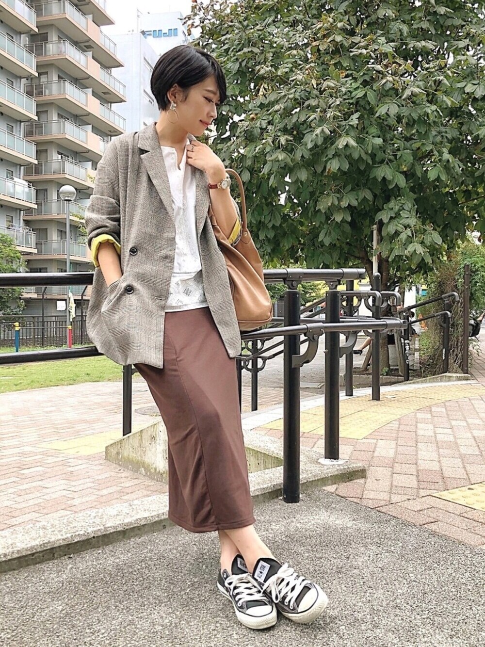 ブラウン系のテーラードジャケット、ブラウン系のスカート、シルバー系のピアス(両耳用)を着用したレディースの秋コーディネートの1枚目の写真