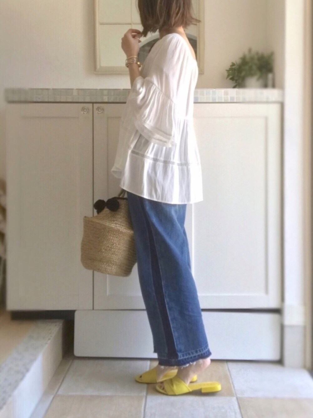 ブルー系のデニムパンツ、ホワイト系のシャツ/ブラウス、ブラック系のかごバッグを着用したレディースの夏コーディネートの1枚目の写真