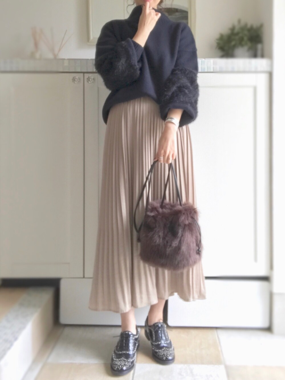 ブルー系のニット/セーター、ベージュ系のスカート、ブラウン系のショルダーバッグを着用したレディースの秋コーディネートの1枚目の写真