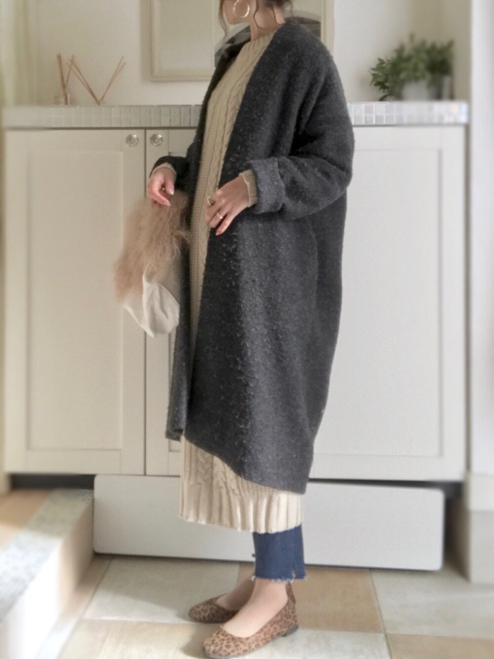 ホワイト系のワンピース、グレー系のチェスターコート、ホワイト系のトートバッグを着用したレディースの冬コーディネートの1枚目の写真