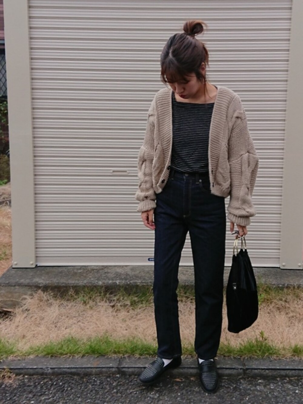 ブラック系のTシャツ/カットソー、ベージュ系のカーディガン/ボレロ、ブルー系のデニムパンツを着用したレディースの秋コーディネートの1枚目の写真
