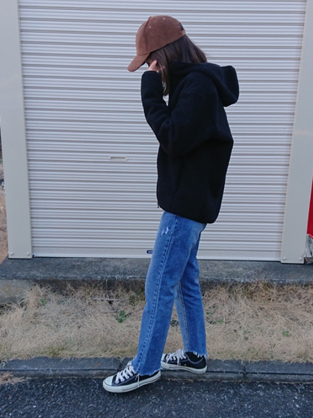 ブルー系のデニムパンツ、ブラック系のその他アウター、ブラック系のスニーカーを着用したレディースの冬コーディネートの1枚目の写真