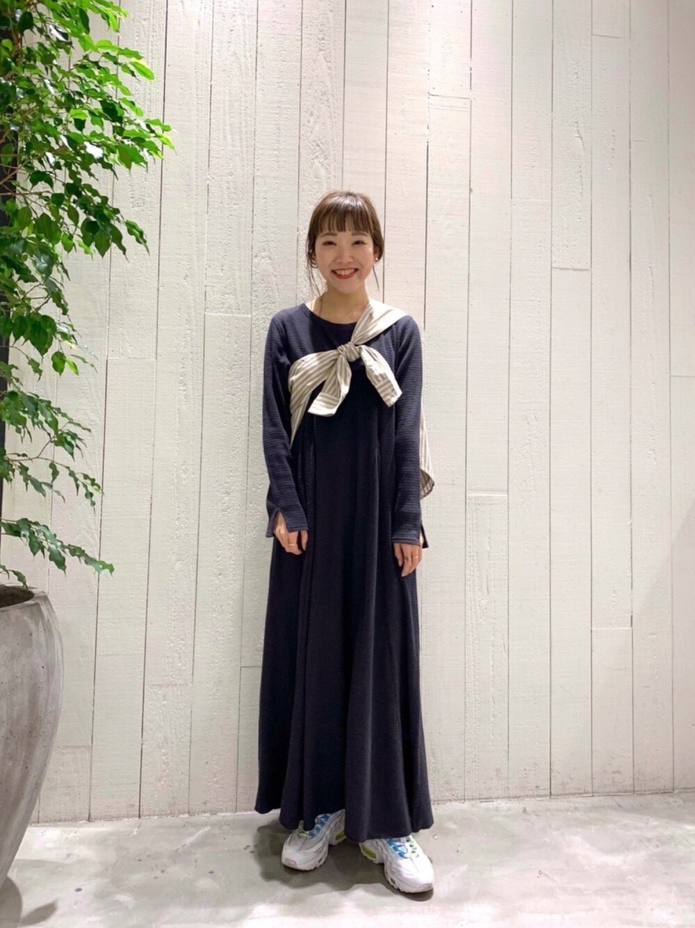グレー系のワンピース、ベージュ系のシャツ/ブラウス、ホワイト系のスニーカーを着用したレディースの春コーディネートの1枚目の写真